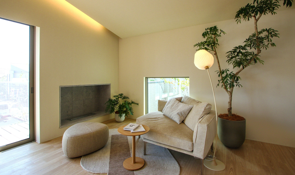 ロートーンで穏やかで落ち着いた温かさを感じるインテリア。暖炉の前には大きな一人掛けソファでくつろぎを。