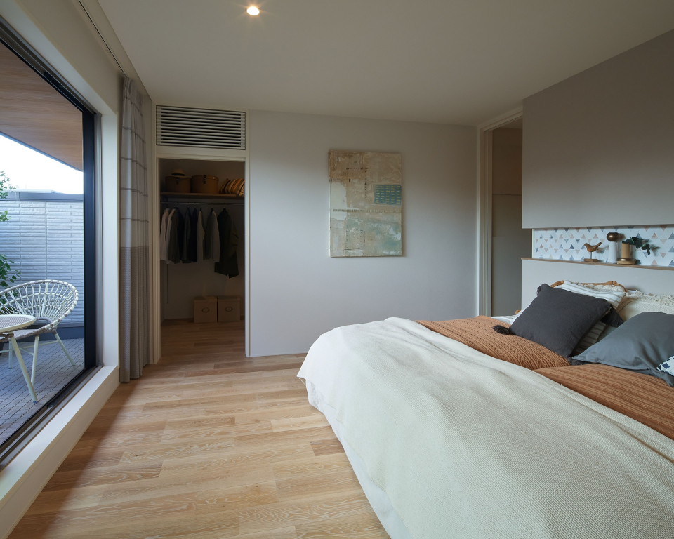 通常より高いハイウォールを用いたプライベートバルコニーへとつながる寝室は、プライバシーの確保と開放感を両立させます。