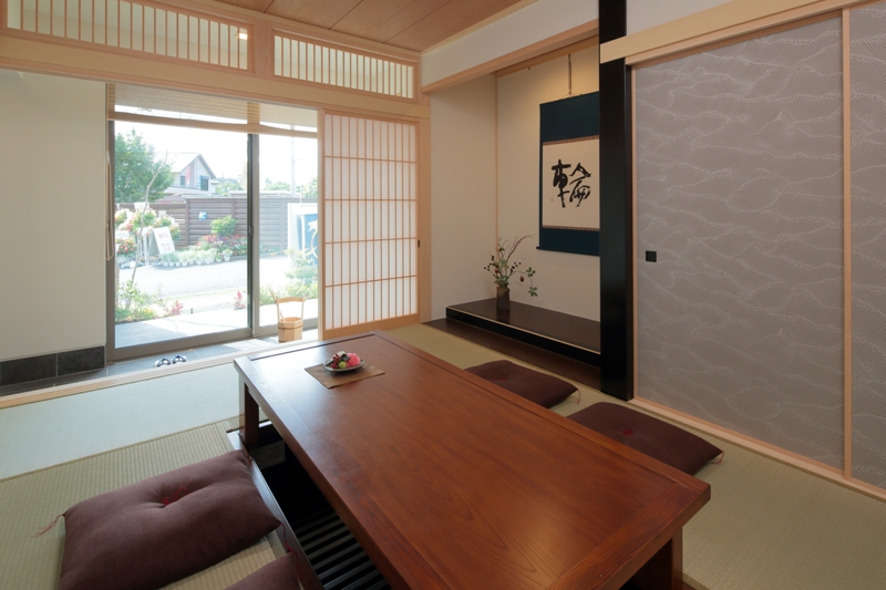 二世帯で共有する本格的な和室は、客間としても活用可能。
コーナー連続窓のある土間広縁とつながり、外へと視線が抜ける解放感が心地よい空間です。