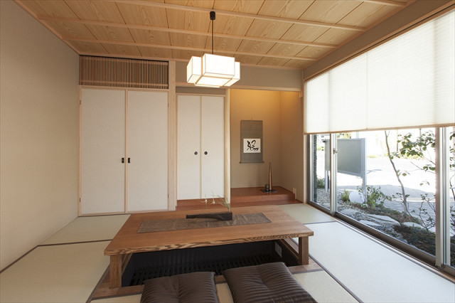 メーターモジュールの６畳和室は、緑豊かな和庭を眺められる設計。
広島で採用されることの多いタイプの仏間をしつらえ、２世帯が共用できる客間です。
掘りごたつを設置していますので、ゆっくりとおくつろぎ頂けます。