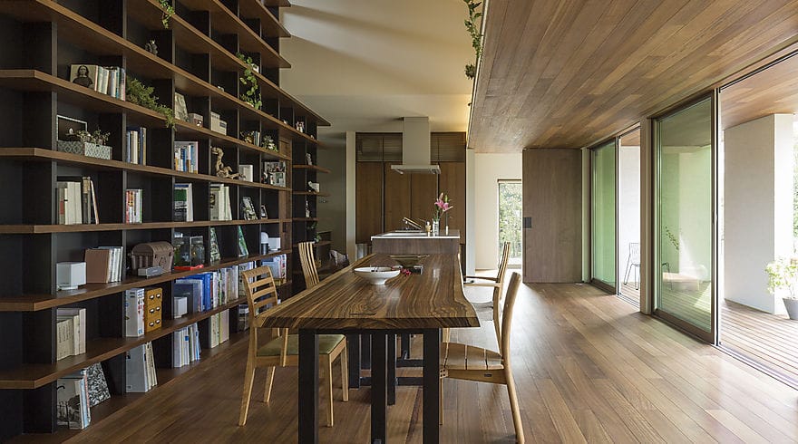 平屋ならではの勾配吹き抜け大空間に、大樹のように木の素材感が際立つ、天井までの本棚が目を引く。